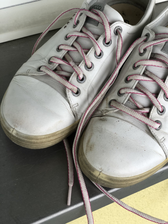 Schmutzige Sneakers warten auf professionelle Schuhpflege